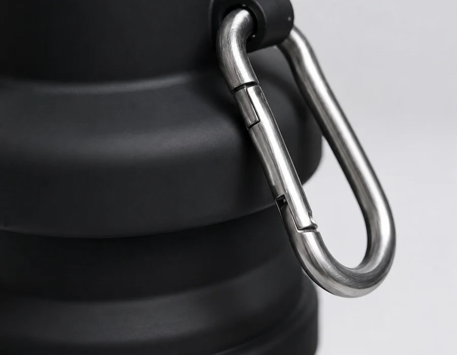 Close view of the metal carabiner clipped to the neck of a Black collapsible bottle